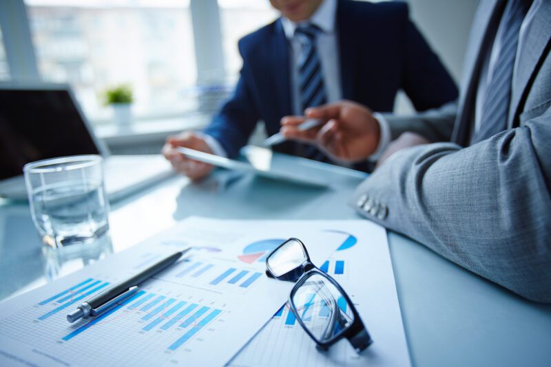 desk with glasses and finance papers